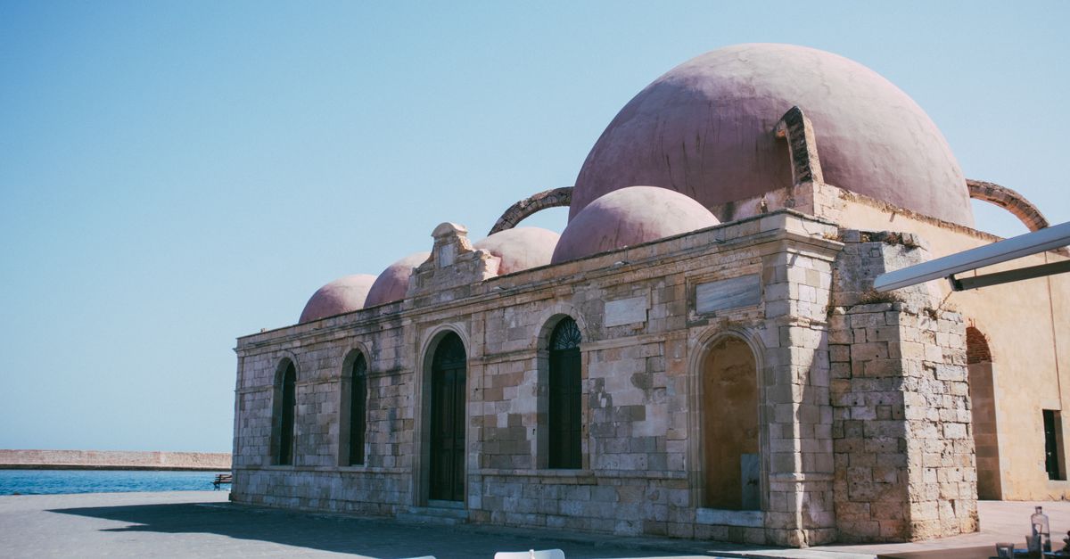 View of a historic Ottoman mosque with domed architecture by the sea.