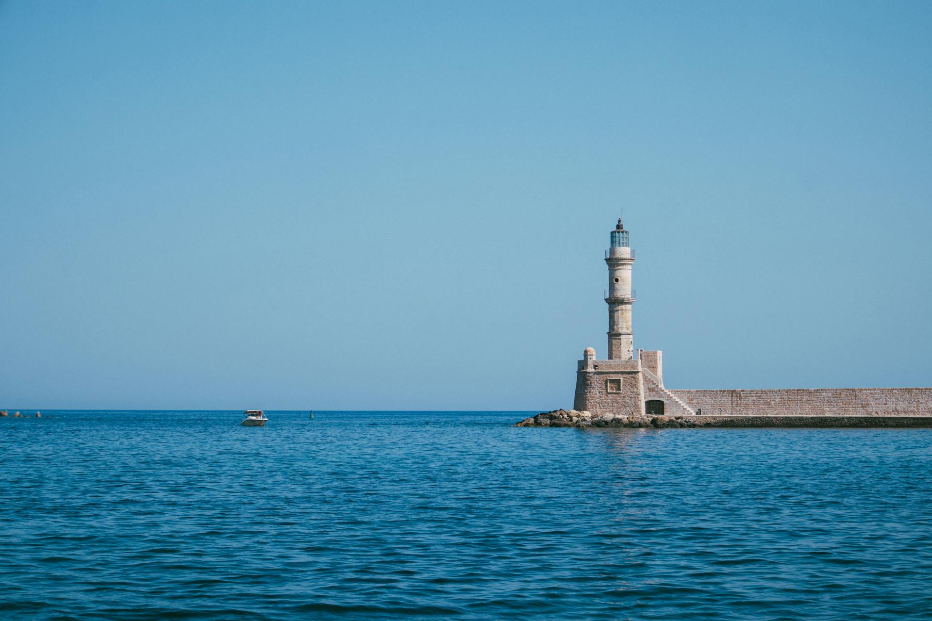 Picturesque lighthouse standing on a calm sea, offering a serene coastal view.