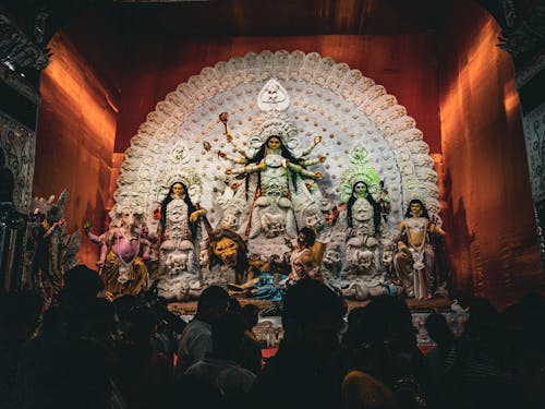 Crowd Standing in front of Figures of Deities in a Temple 
