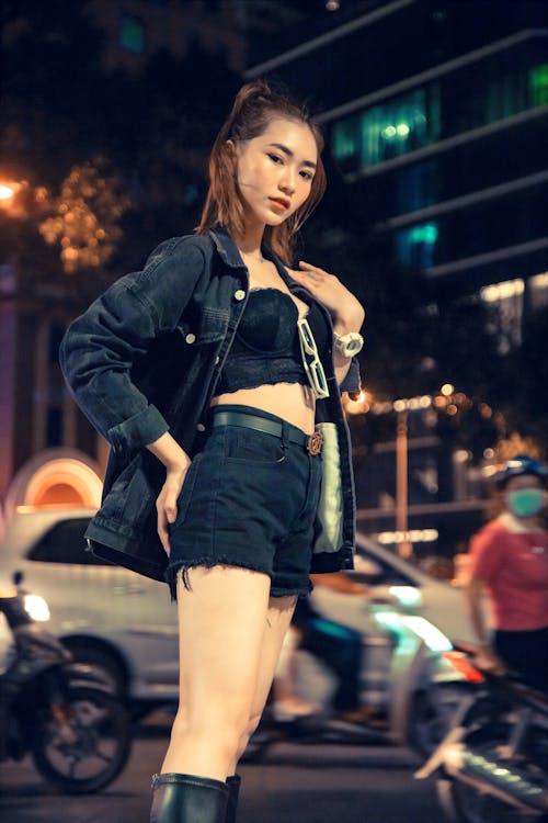 Young Woman on the Background of a Busy City Street at Night 