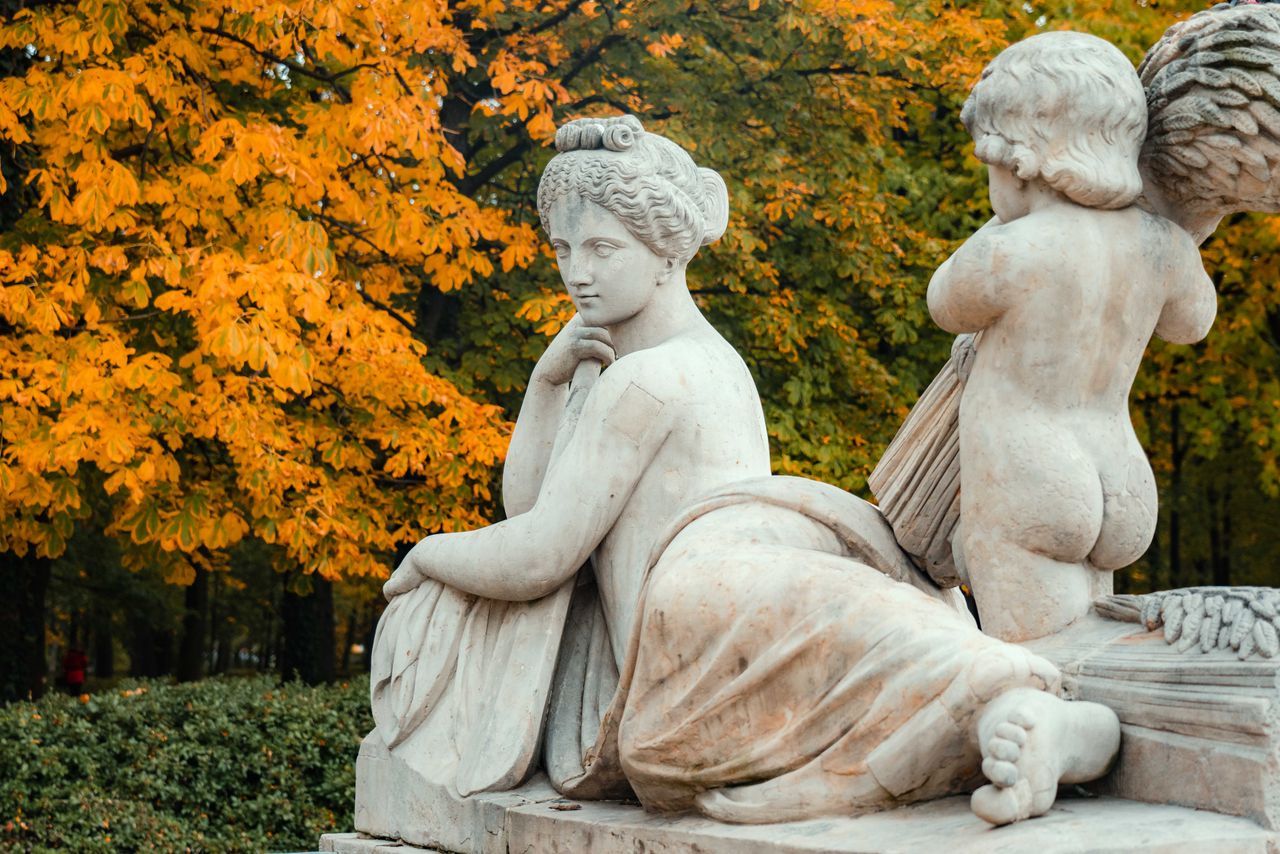 marble sculpture with autumn foliage background in a serene park setti