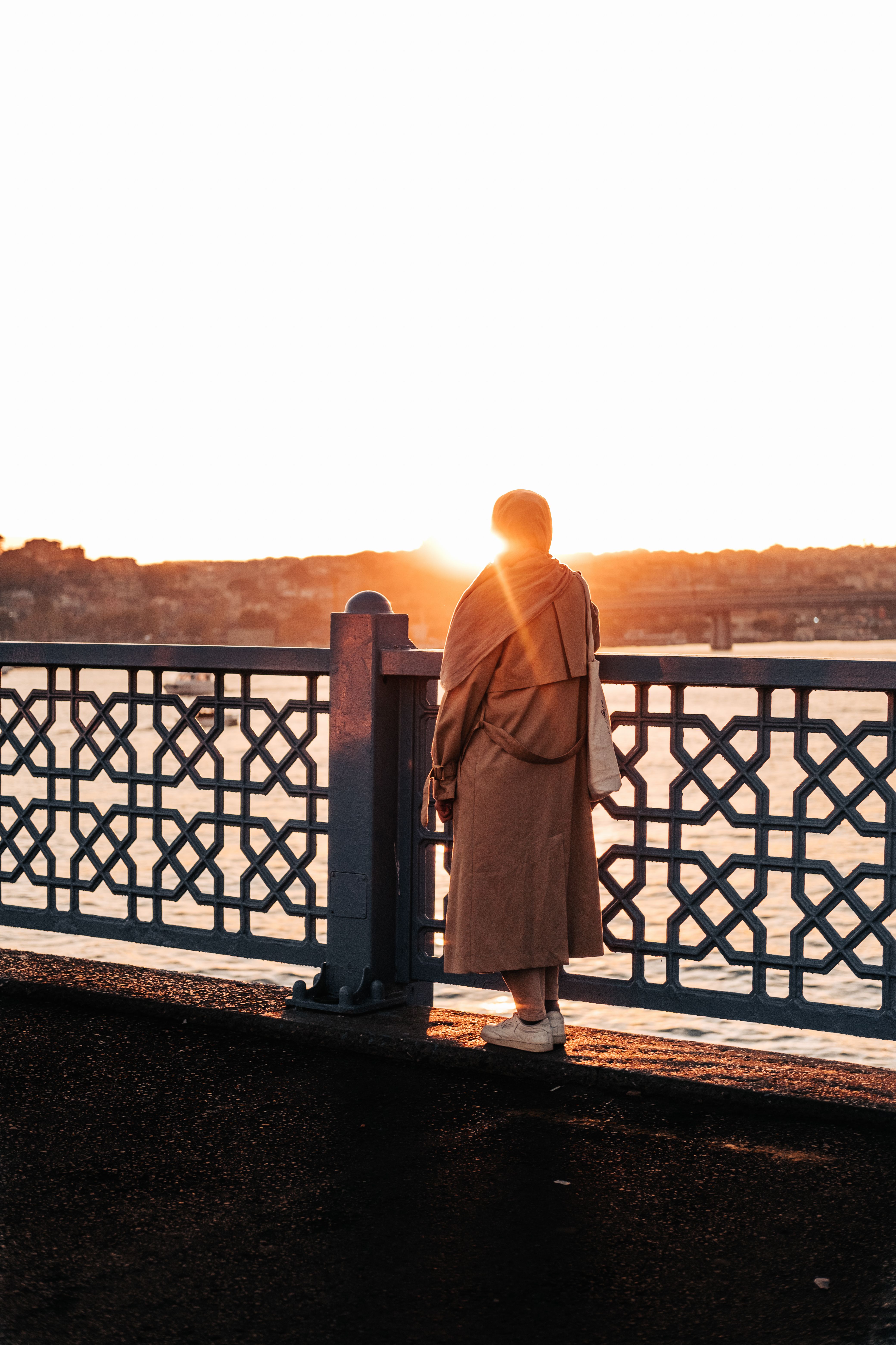Woman Standing on a Bridge at Sunset · Free Stock Photo