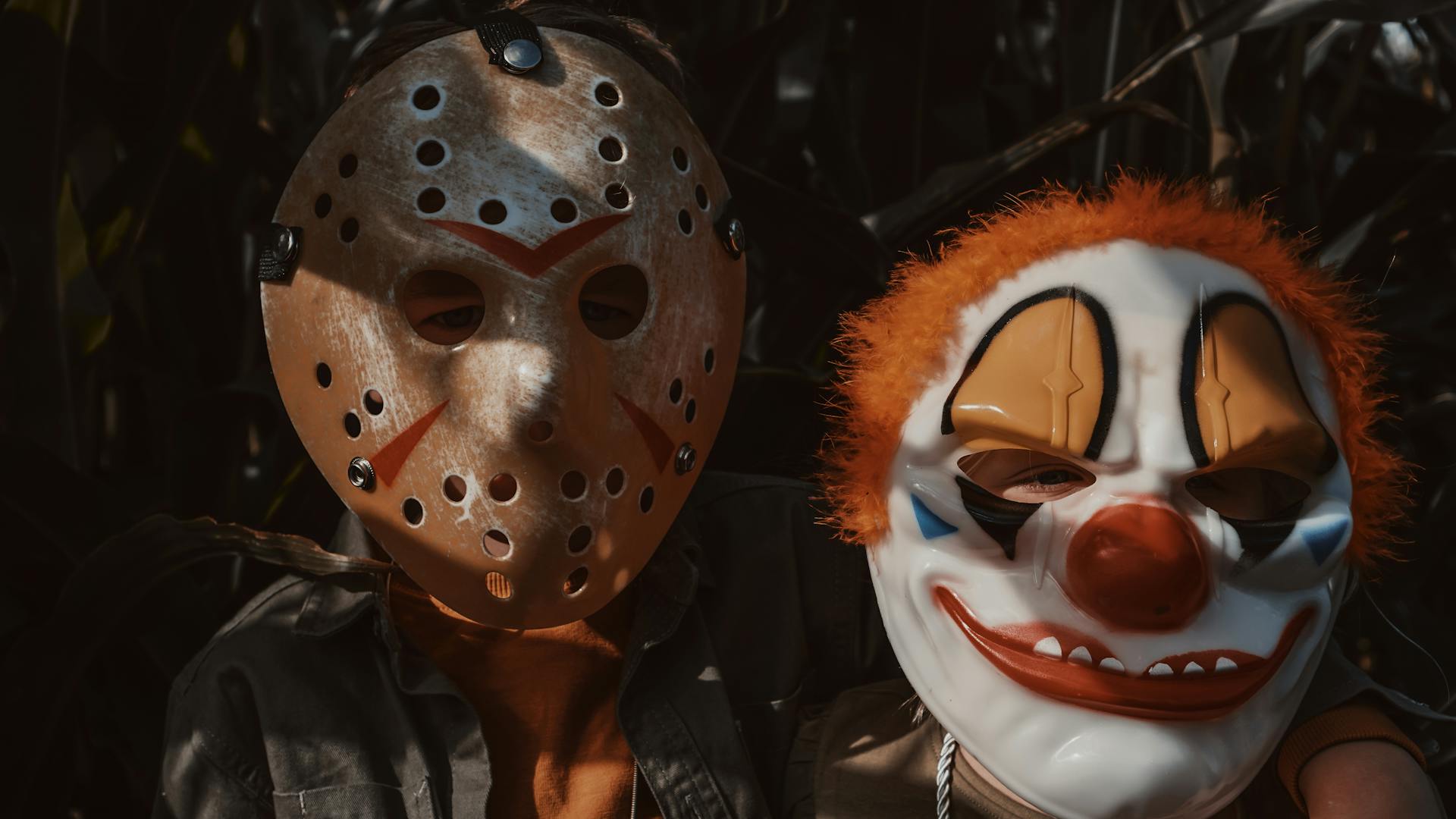 Children Wearing a Jason Voorhees Halloween Mask and a Scary Clown Mask Standing in a Corn Field