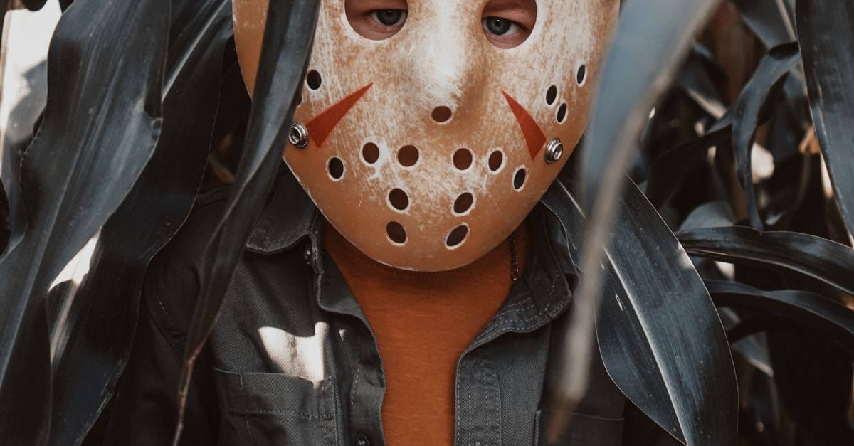 A Boy in a Jason Voorhees Halloween Mask Standing in a Corn Field ...