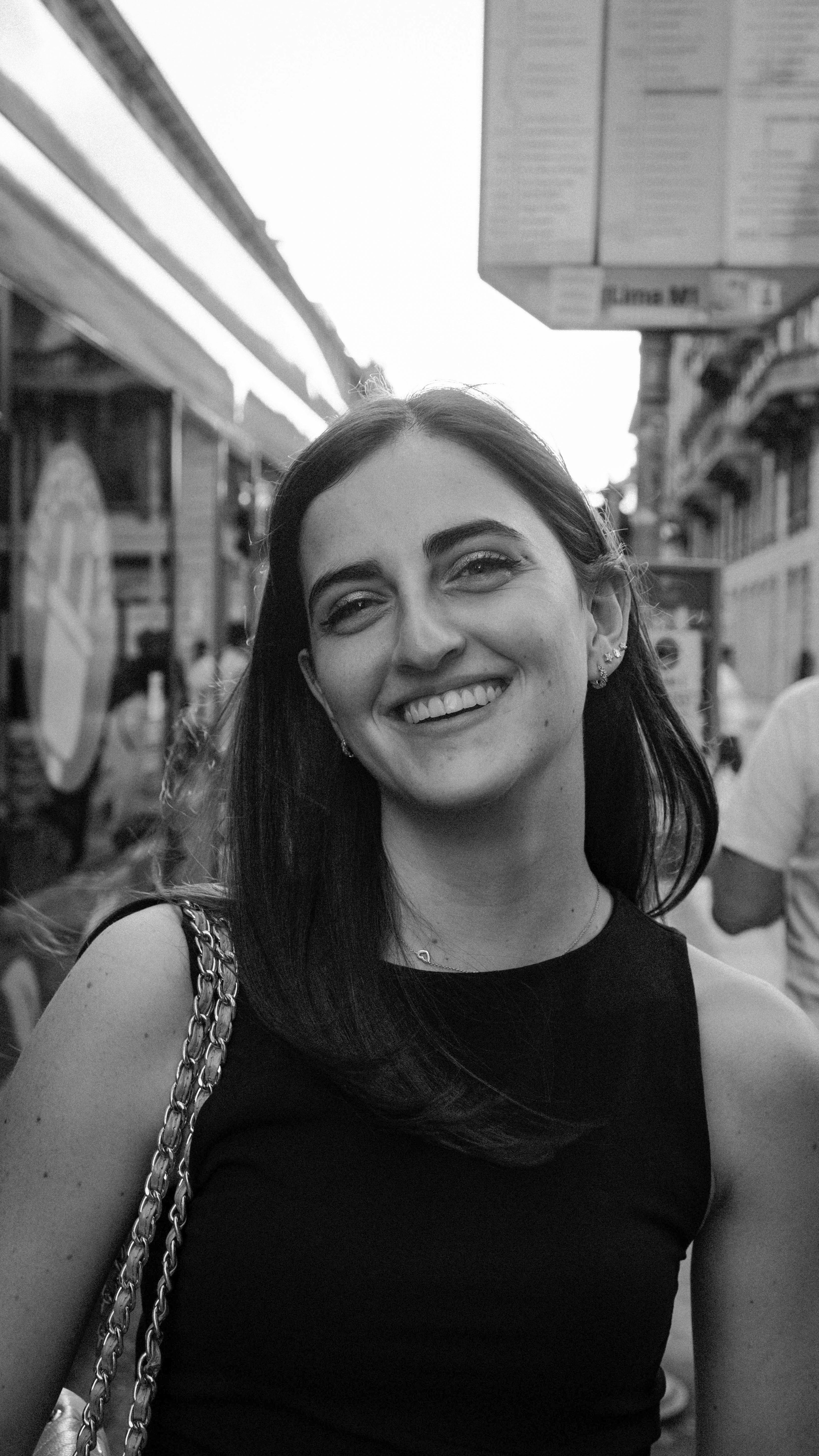 Black and white portrait of a smiling woman outdoors in Milan, Italy.