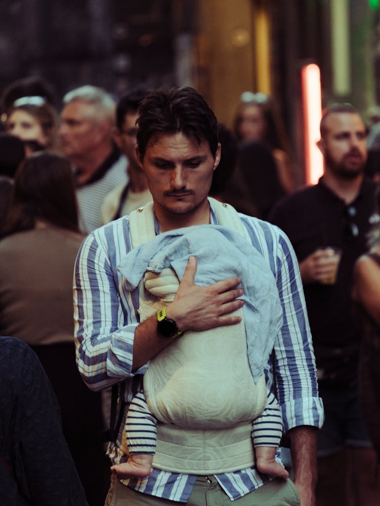 Man Carrying His Child In A Baby Carrier 