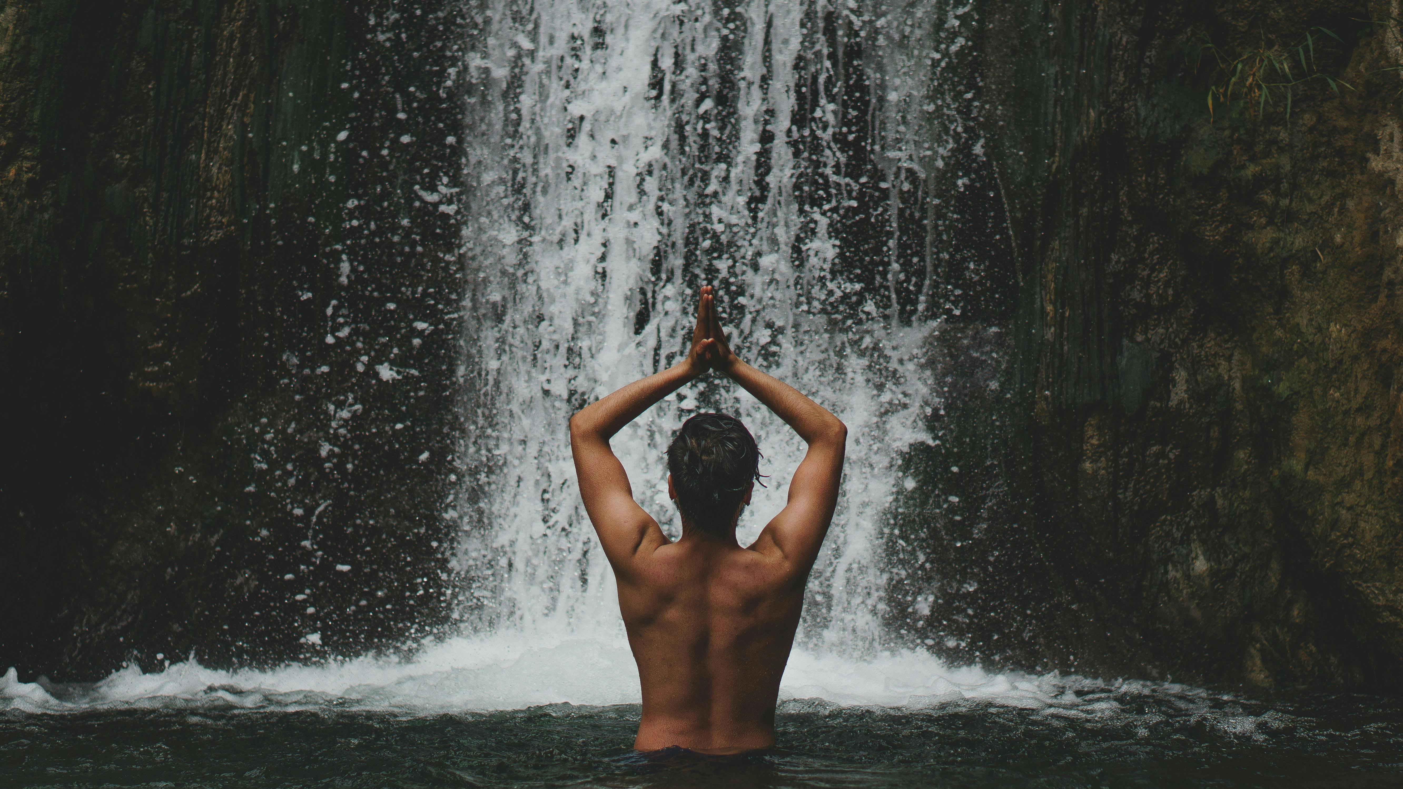 person standing beside waterfalls