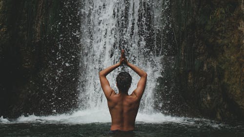 Person Standing Beside Waterfalls