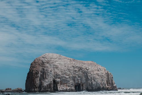 無料 青い空の下のビーチの灰色の岩の形成 写真素材