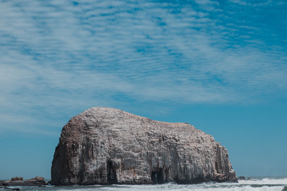 Gray Rock Formation on Beach Under Blue Sky