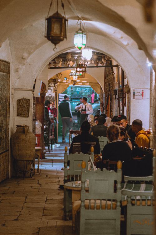 Free Cozy Tunisian restaurant scene with people dining under an arched ceiling. Stock Photo