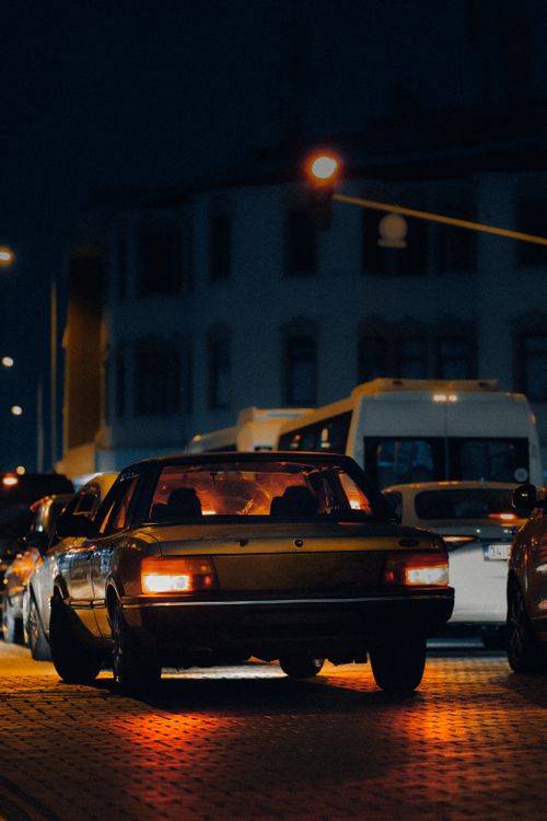 Free A vibrant city street captured at night featuring illuminated vehicles and bustling traffic. Stock Photo