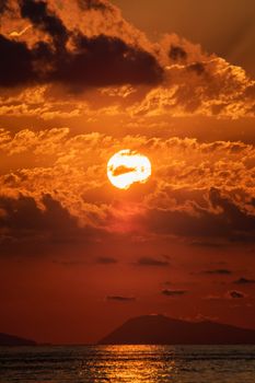 Beautiful sunset over Bagnara Calabra, Italy, with golden clouds and sea reflections.