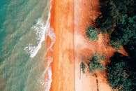 令人惊叹的鸟瞰图展示了充满活力的沙滩、郁郁葱葱的绿植和翻涌的海浪