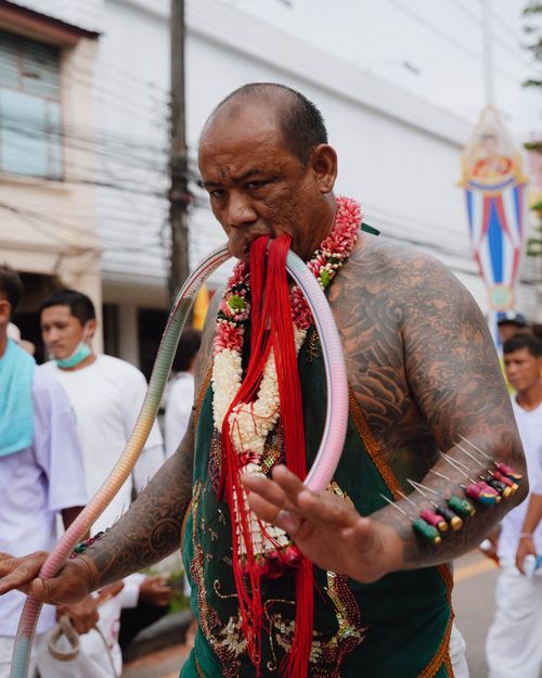 Free Man with extensive tattoos and piercings participates in traditional festival in Phuket, Thailand. Stock Photo