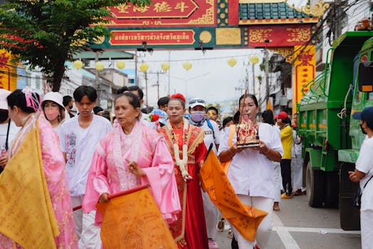 Vibrant street parade during the Vegetarian Festival in Phuket, Thailand, showcasing traditional attire and cultural expressions.