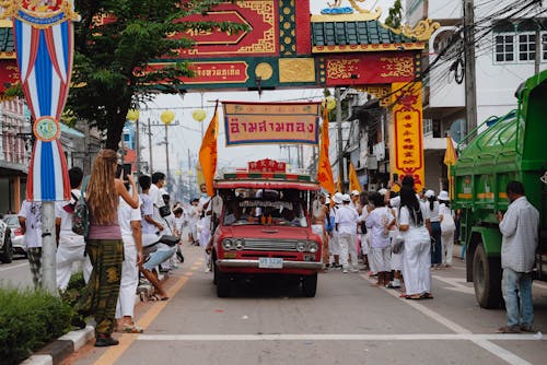 Foto gratuita de coches conduciendo por la calle durante un festival en Tailandia