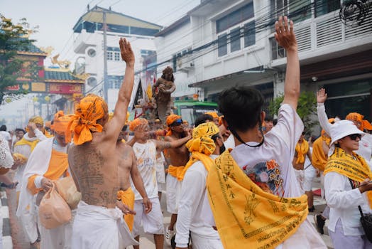 Participants celebrating a traditional festival parade in Phuket, Thailand.
