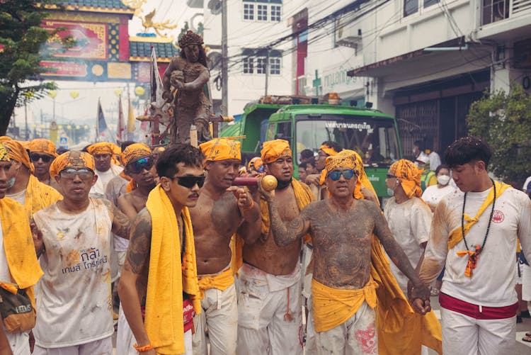 Men In Traditional Clothes Carrying Statue During Festival