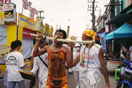 Energetic street scene during the Phuket Vegetarian Festival featuring traditional rituals and colorful attire.