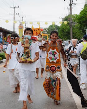 Participants in traditional attire parade during Thailand's vibrant Vegetarian Festival, showcasing rich cultural heritage.