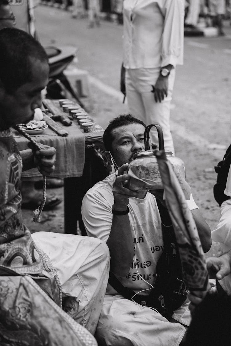 Man Drinking Water From Kettle On Street Festival