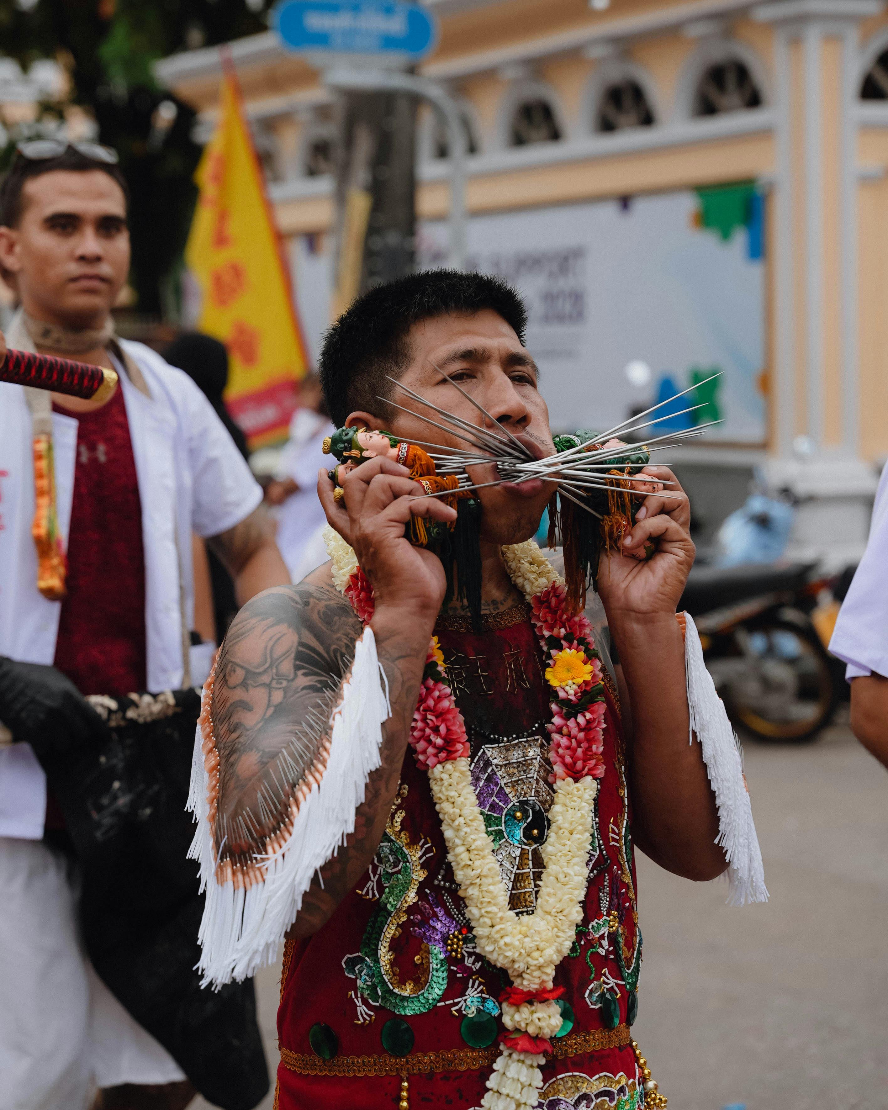 man in traditional costume with cheek piercing on festival