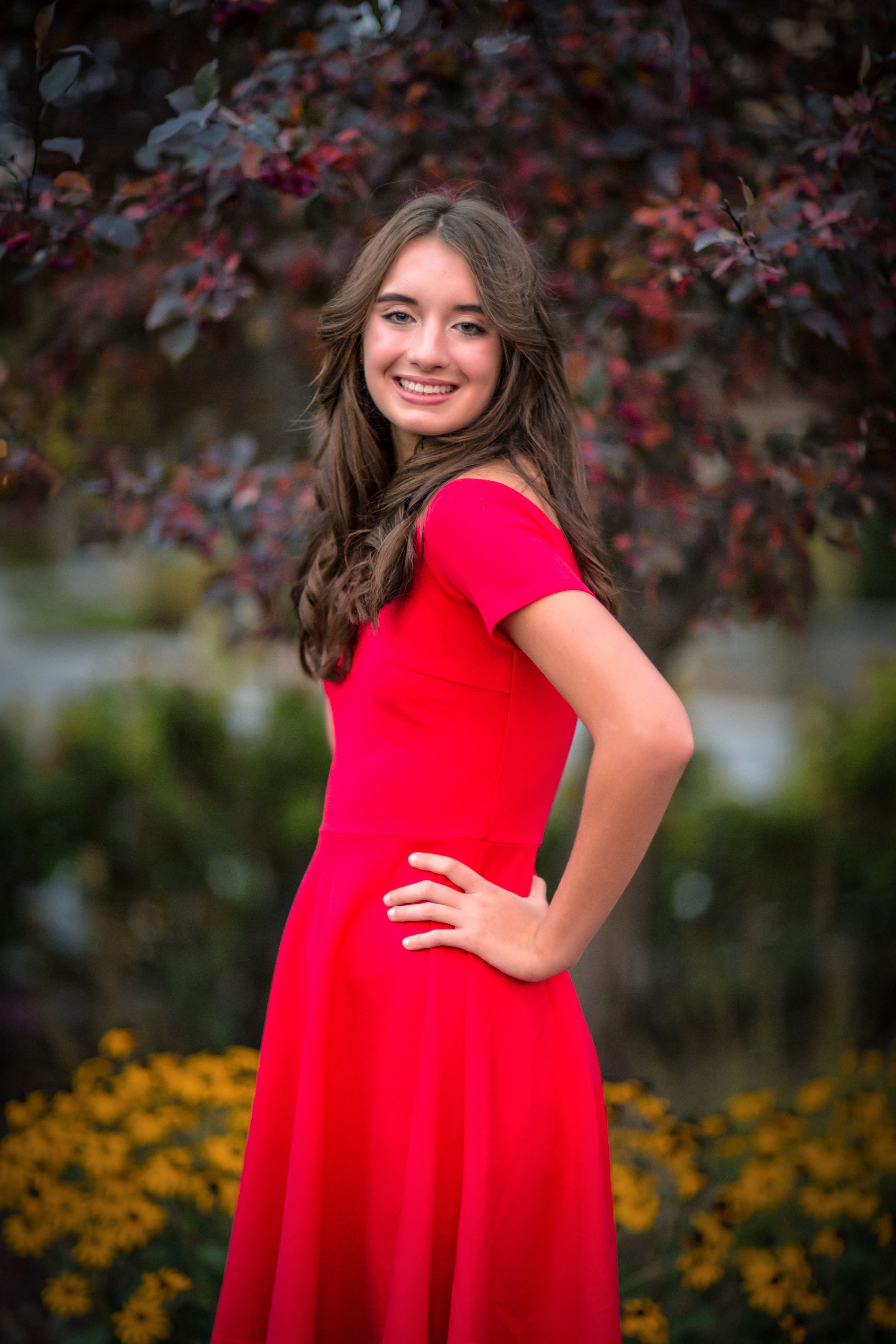 A Woman in Red Dress Smiling while Looking Over Shoulder · Free Stock Photo