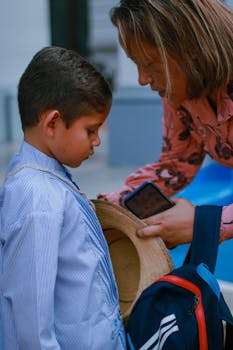 A mother helps her young son with his backpack, preparing for a school day.