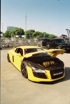 A striking yellow sports car with a custom hood displayed outdoors in Barcelona, capturing automotive elegance and power.