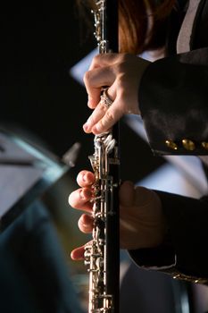 Vertical shot of hands playing a clarinet, highlighting musical expression and technique.