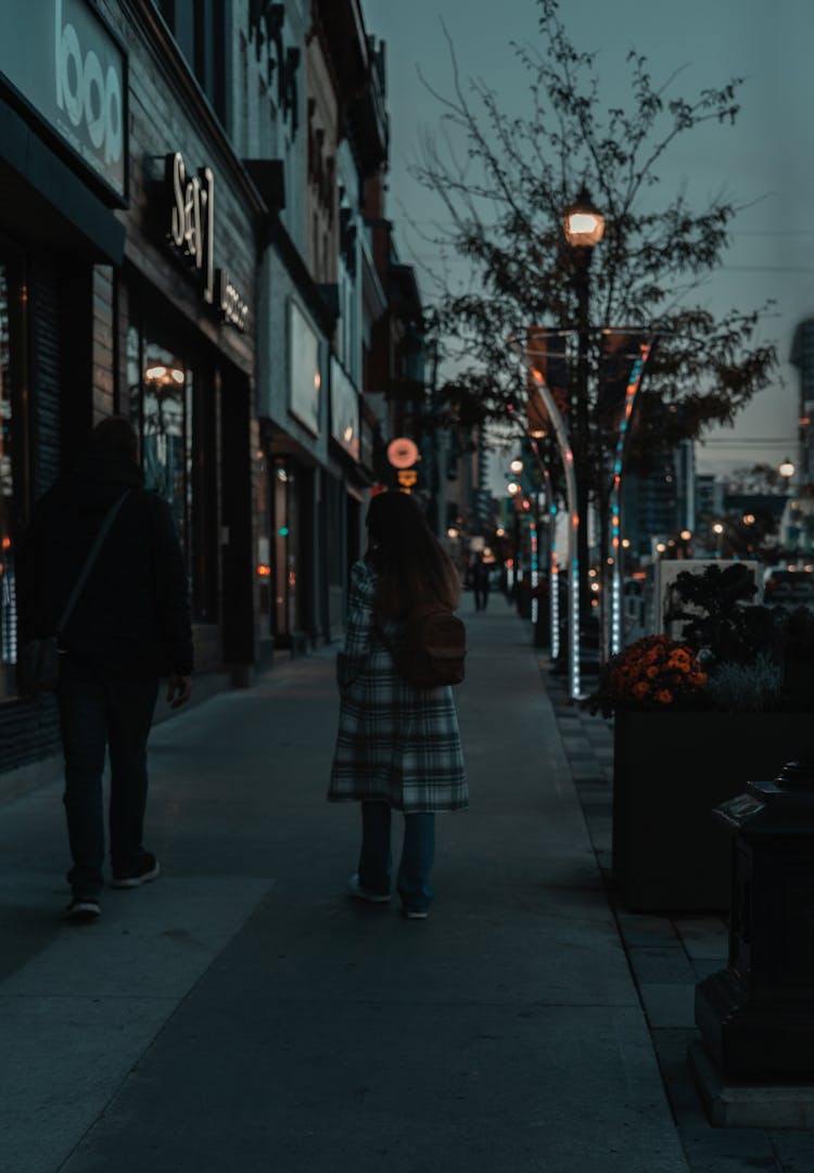 Man And Woman Walking On Sidewalk