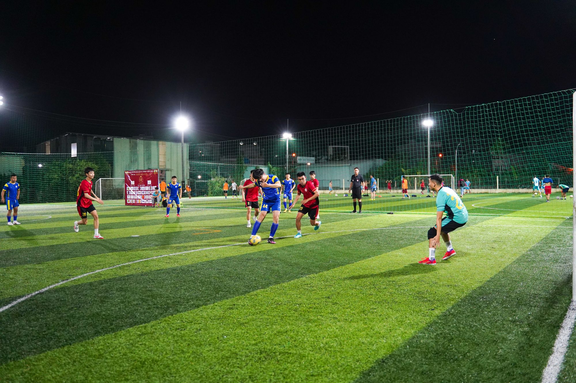 Five-a-side football match on an artificial turf pitch under floodlights