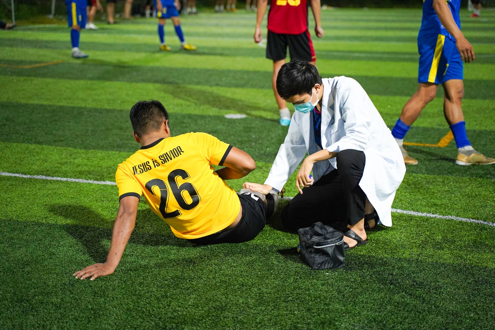 Soccer player receiving medical aid on the field for injury during a match.