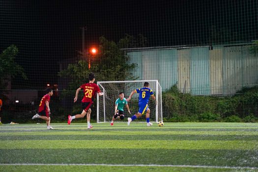 Youth soccer players in action on a lit field at night, showcasing teamwork and energy.
