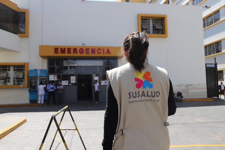 A Woman Standing In Front Of A Hospital