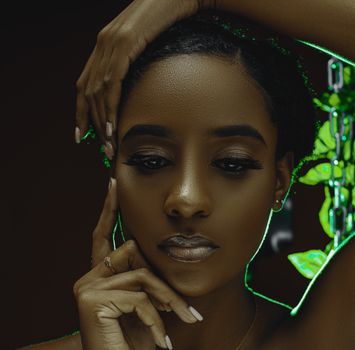 Close-up portrait of a woman with a serene expression, featuring delicate lighting and a subtle green glow.