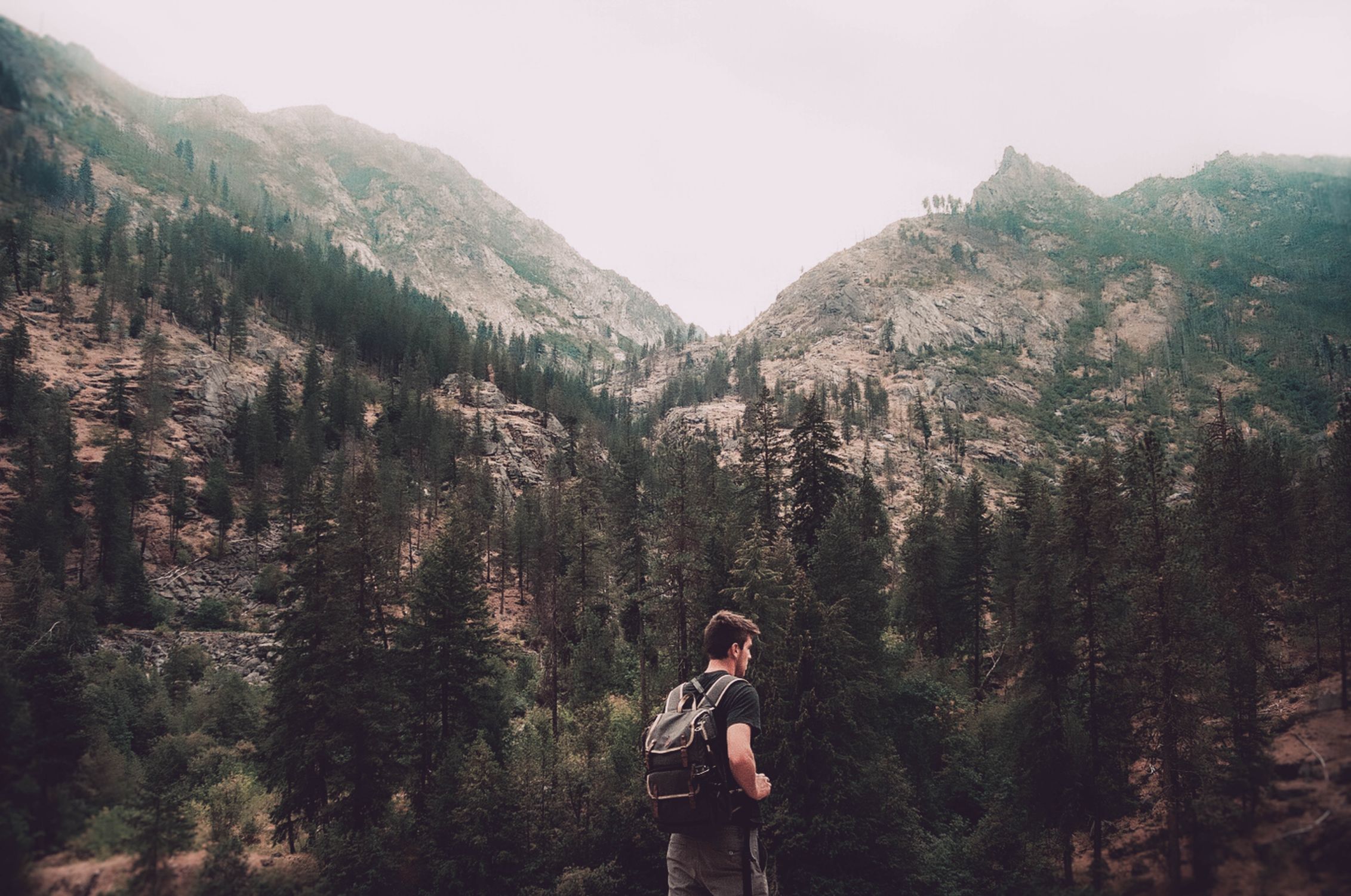 A hiker with a backpack exploring the mountainous landscape of Leavenworth, WA.