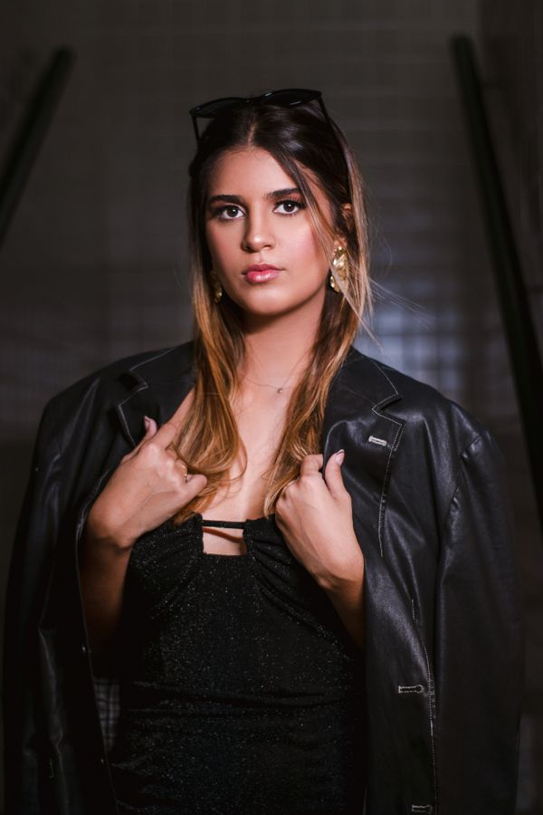 Woman in leather jacket with sequin top and black jeans