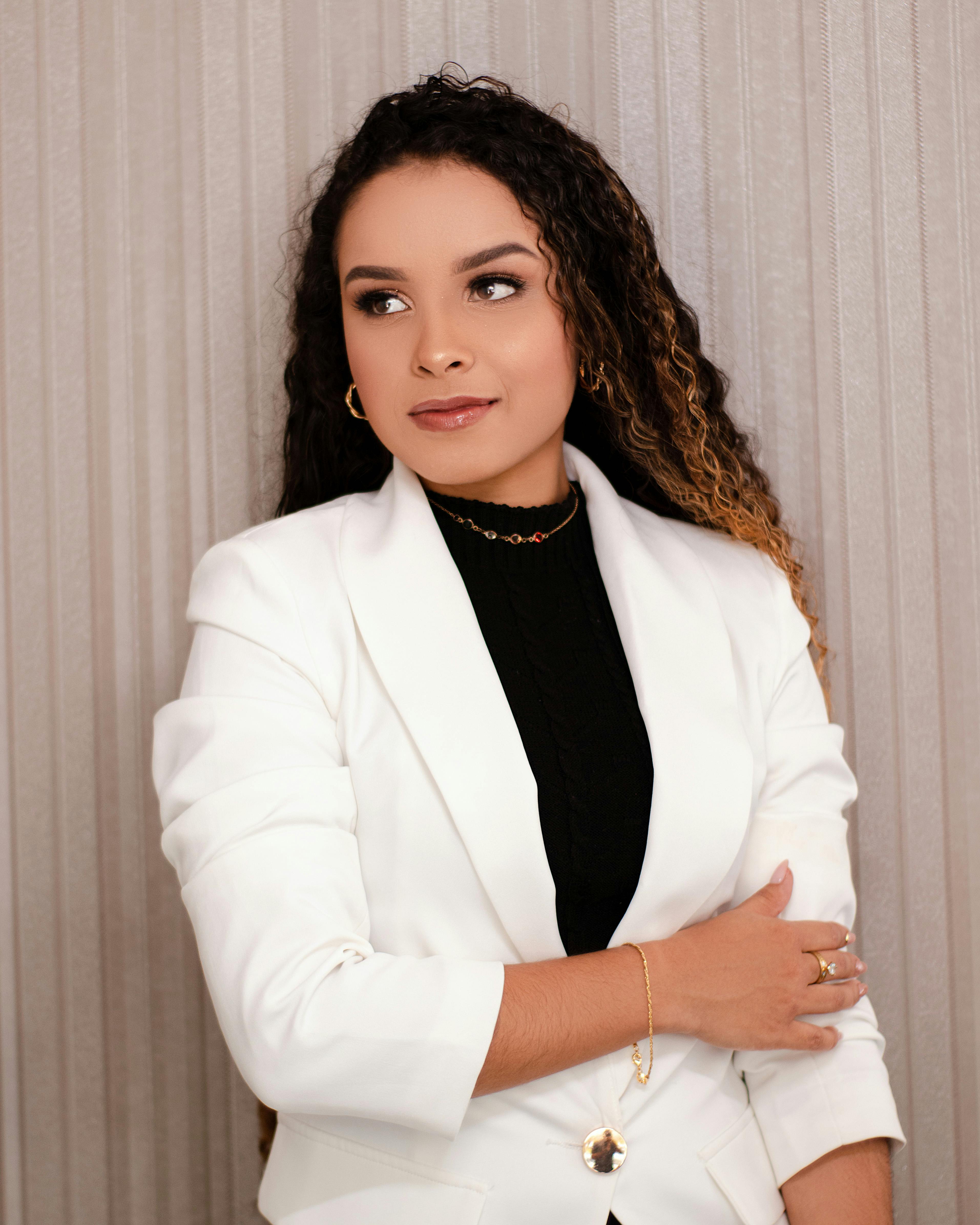 Stylish and confident business portrait featuring a young woman in a white blazer with a sophisticated expression.