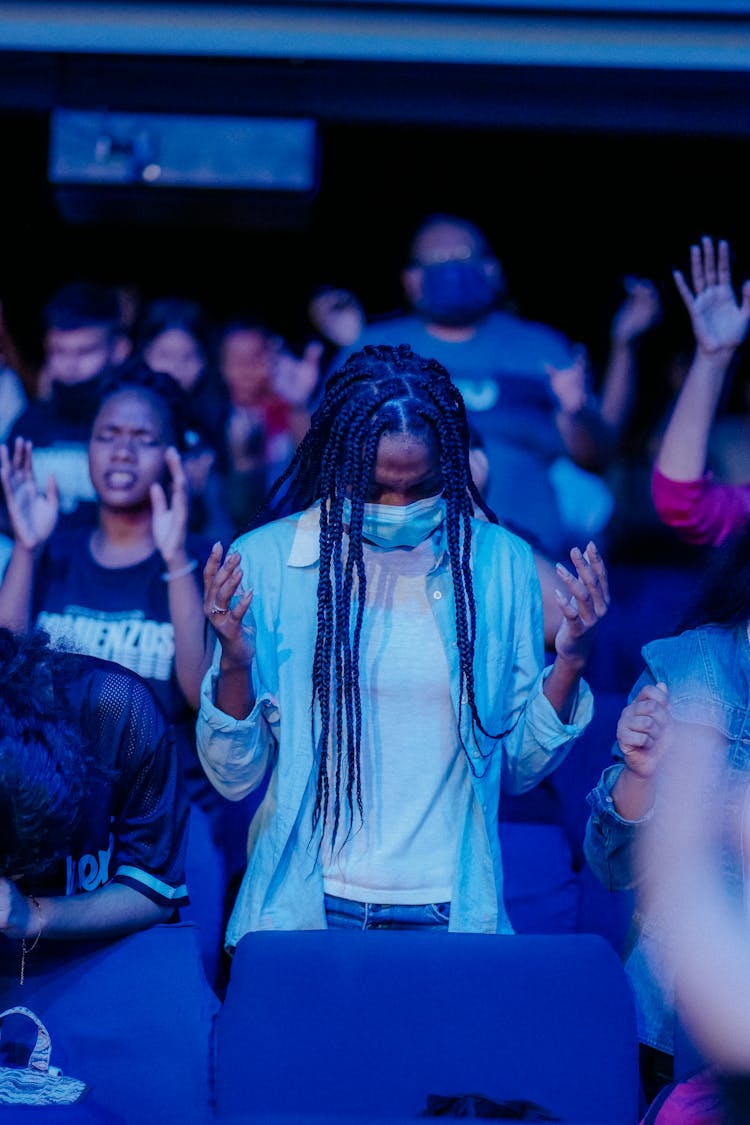 People With Raised Hands In An Audience 