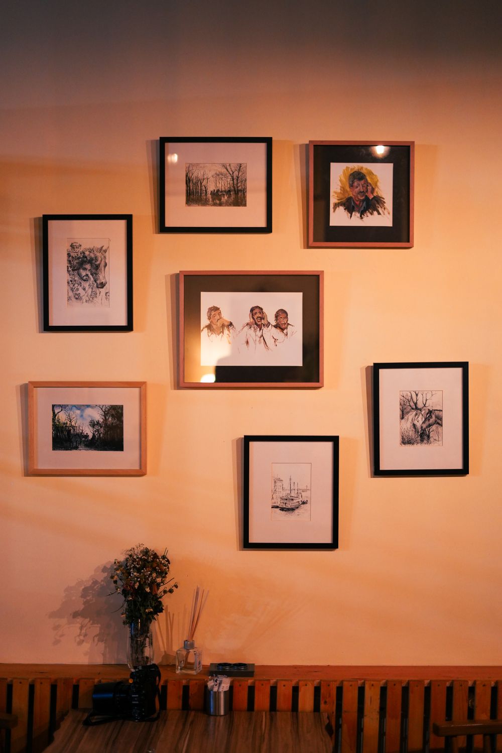 Traditional framed artworks and illustrations displayed on a warm interior wall