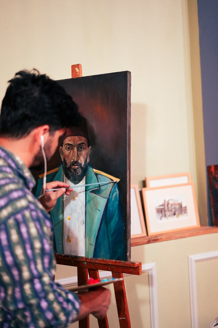 Man In Headphones Painting On Easel