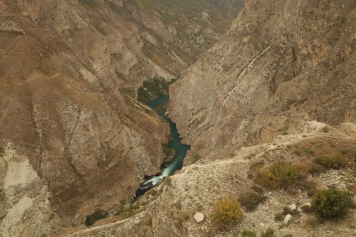 Free Stunning aerial view of a canyon with turquoise river cutting through rugged brown mountains. Stock Photo