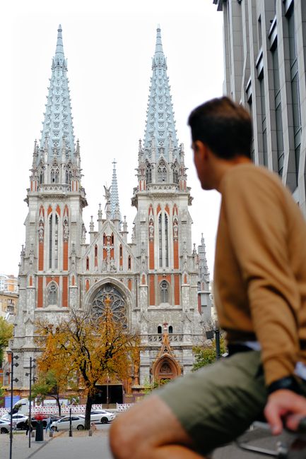 A young man sits overlooking the grand architecture of St. Nicholas Cathedral in Kyiv, Ukraine.