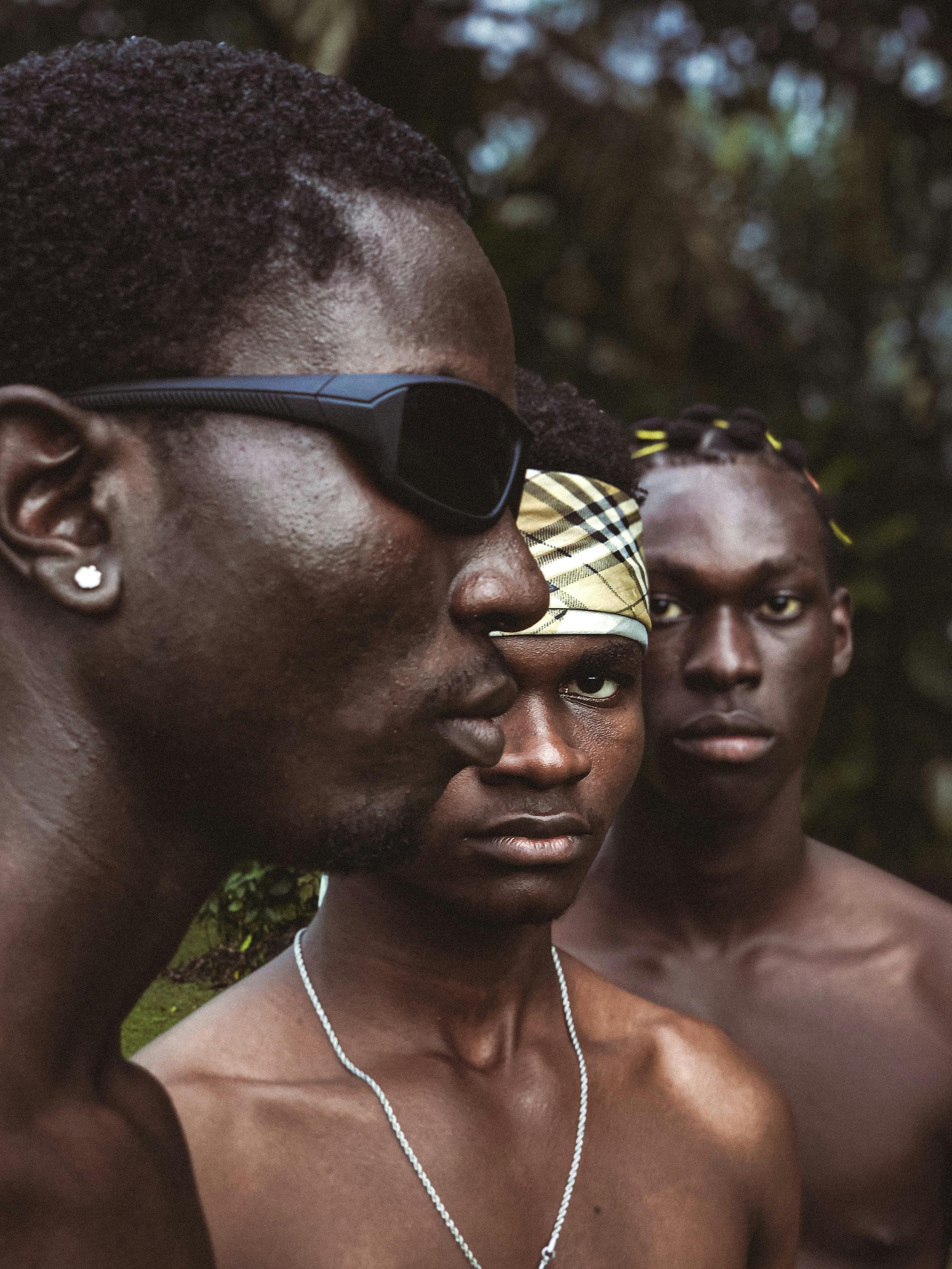 shirtless men standing in nature