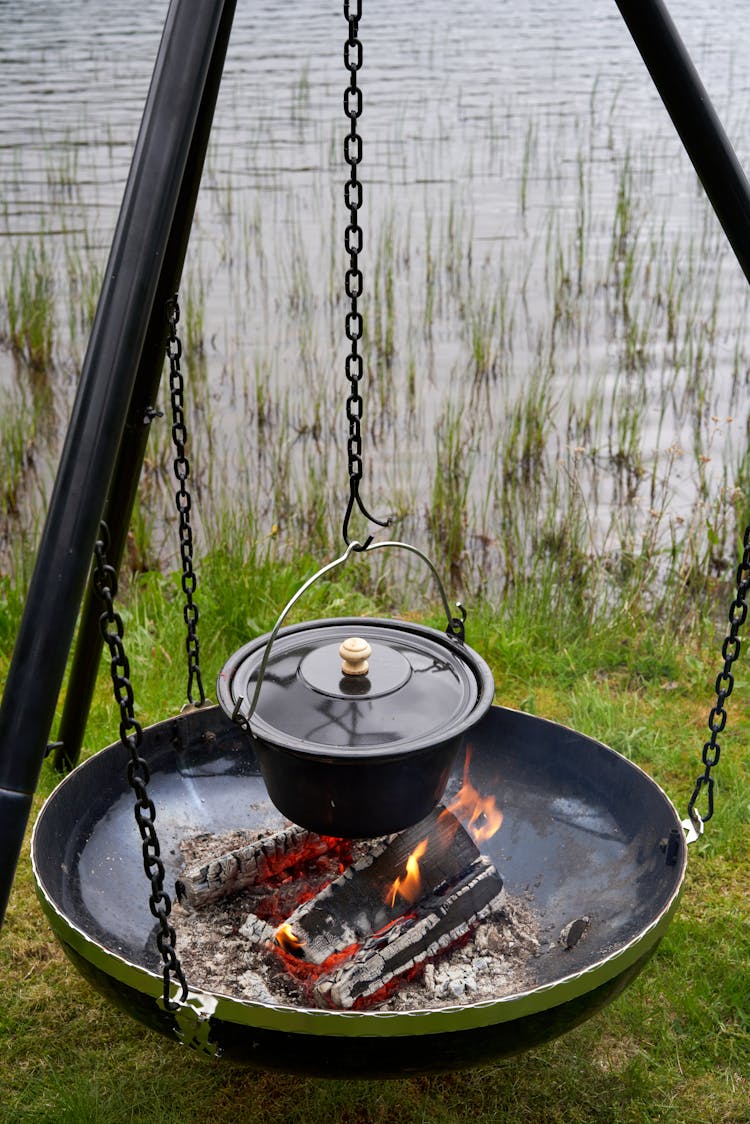 Cooking In Pot On Fire Near Lake In Nature