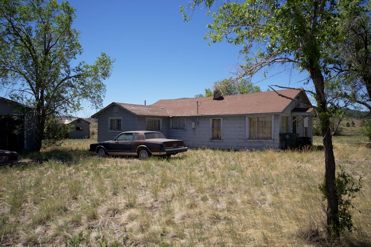 Black Car Parked Beside Brown House