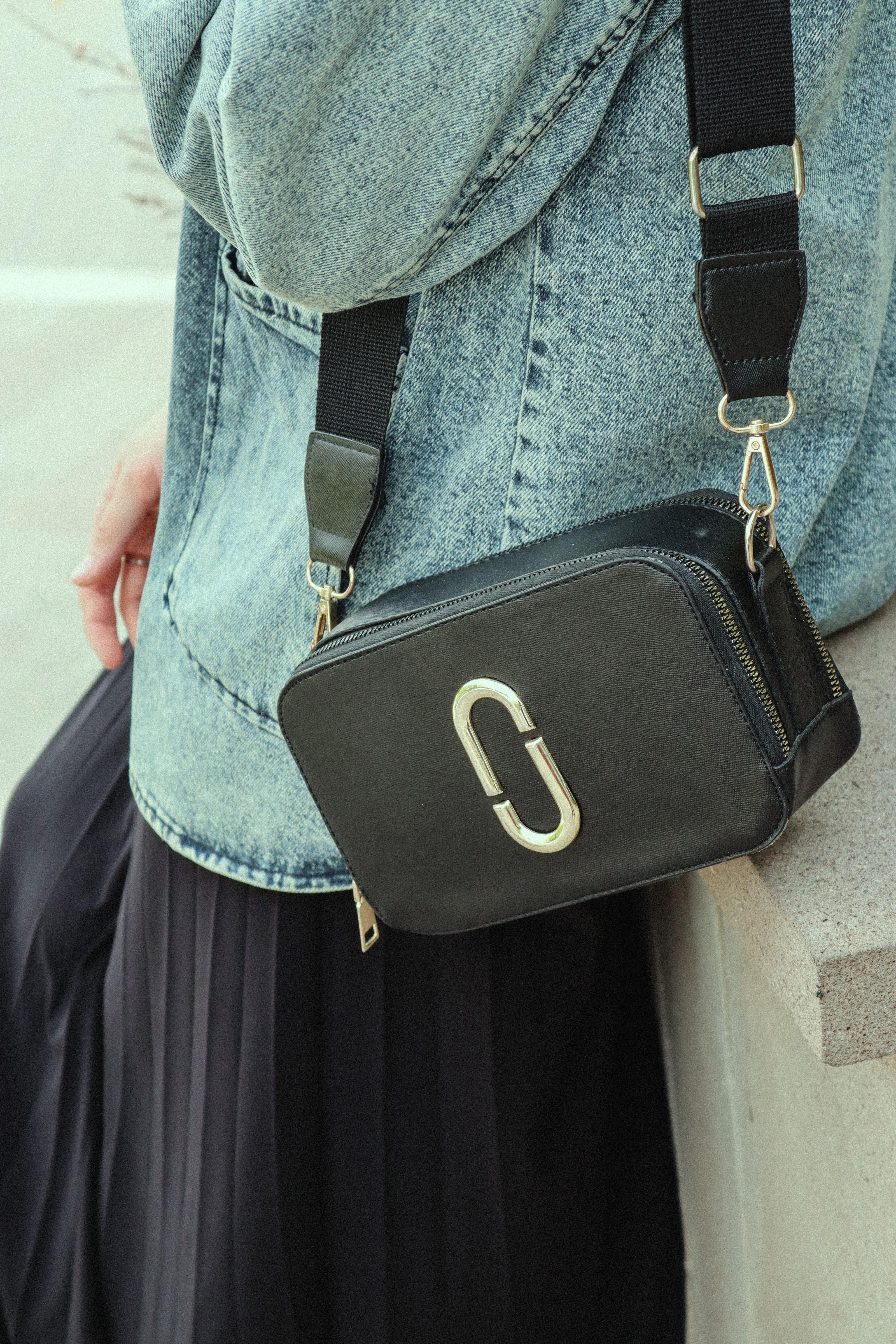 Close-up de uma jaqueta jeans fashion com uma bolsa preta trendy e saia.