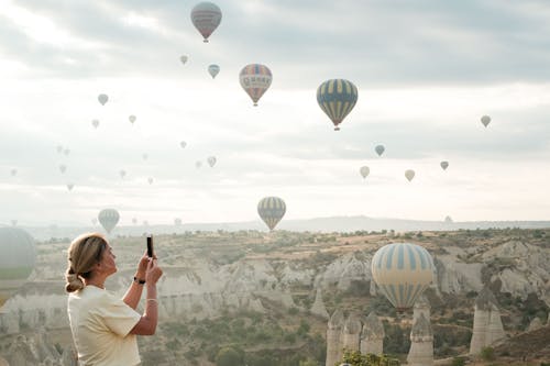 Woman Taking Photo of Hot Air Balloons in Cappadocia